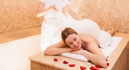 Hammam female client enjoying foam massage in Turkish bath. Procedures in oriental bath improves...