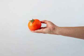 Orange fruit in hand isolated on white background.