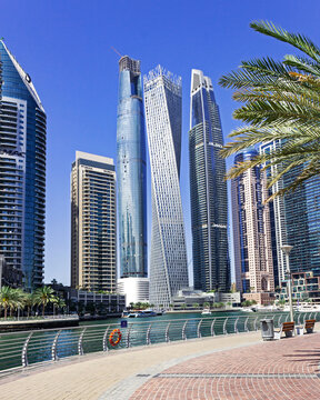 Dubai, United Arab Emirates &ndash; March 6, 2024: Dubai skyline. Dubai Marina skyscrapers with popular twisted Cayan Tower, view from the Marina Walk &ndash; famous walking promenade