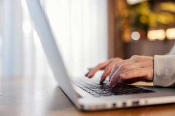 Close up of hands typing on a laptop.