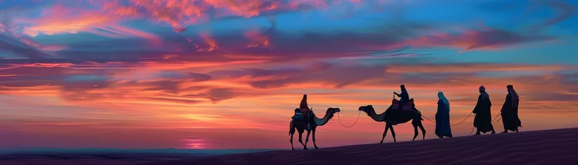 Selbstklebende Fototapeten Silhouetted figures with camels walking in a desert at sunset, with vibrant orange and blue sky. © Moopingz