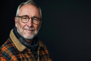 Obraz premium Elderly man smiling at camera. A close-up portrait of an elderly, man with a warm smile, wearing fashionable clothes.