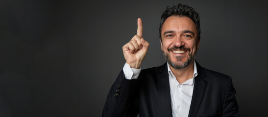 A man in a suit is smiling and pointing his finger. Concept of positivity and confidence. a 35 year old european gentleman raising his finger up to show he is happy