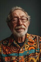 Obraz premium Elderly man smiling at camera. A close-up portrait of an elderly, man with a warm smile, wearing fashionable clothes.