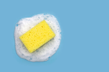 Cleaning sponge in foam of dishwashing liquid. Washing dishes concept
