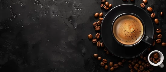 Tuinposter cup of black coffee surrounded by coffee beans on rustic black background  © Menganga