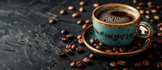  cup of black coffee surrounded by coffee beans on rustic black background  © Menganga