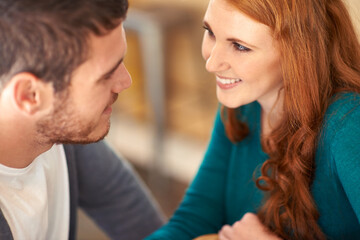 Fototapeta premium Couple, bonding and together with smile in cafe, love and happiness for peace in relationship. Adult, woman and girl with man or partner in coffee shop, excited and joy for marriage with guy