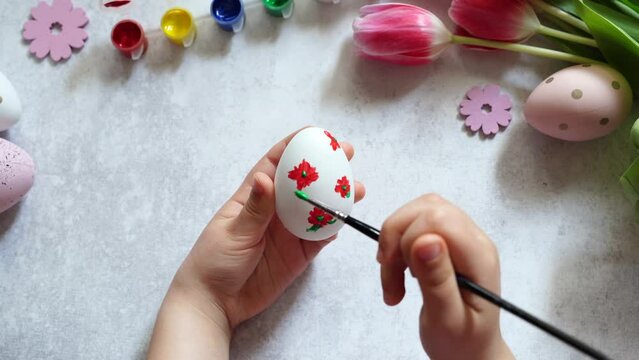 Child painting Easter egg at home
