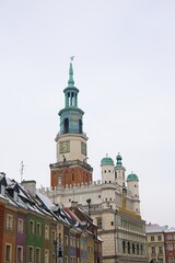 A winter scene of Poznań's old market square captured in January. Snow-covered roofs, the iconic...
