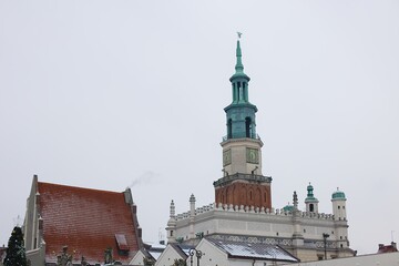 A winter scene of Poznań's old market square captured in January. Snow-covered roofs, the iconic town hall, and clear skies.