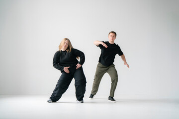 Contemporary Dance Duo Performing Routine Moves in a white Studio - 762187395