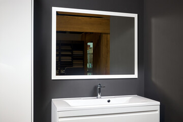 Stoneware countertop bathroom with dark tired beton wall. White industrial flat loft bathroom with modern countertop basin, square mirror and wooden PVC cupboard.