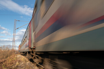 Train passing with motion blur in Banja Luka countryside, railroad travel passenger train closeup