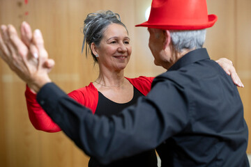 close up senior woman dancing holding hands with her partner in classical latin dance class