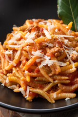 Piatto di deliziosi malloreddus con ragù di carne e pecorino, pasta sarda, cibo italiano 