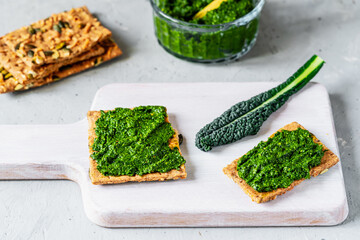 Crispbread with Fresh Kale Pesto Spread on Cutting Board