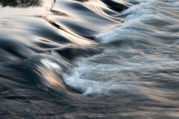 Rapid water flows in stream over stony bottom making cascades - abstract landscape close up - obrazy, fototapety, plakaty