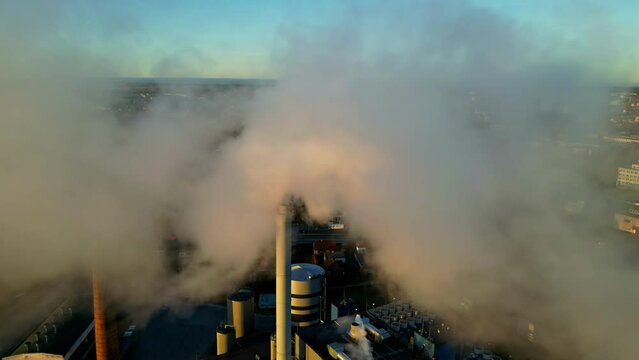 Aerial view of fly though smoke emitted by chimney polluting urban landscape