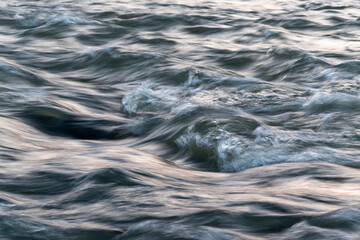 Turbulent water surface in wind, water waves close up, abstract landscape