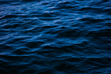 Blue ocean water with waves background. An abstract background of seawater flow under light...