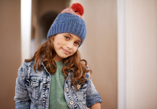 Girl, portrait and child with fashion in winter at home with pride and happiness in clothes with hat. Kid, smile or relax in house with beanie, jacket or casual style on holiday or vacation in Sweden