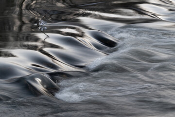 Rapid water flows in stream over stony bottom making cascades - abstract landscape close up