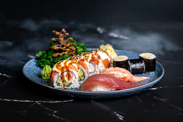 luxury sushi set with nigiri, maki and rolls on a black background with side dishes © Ondrej
