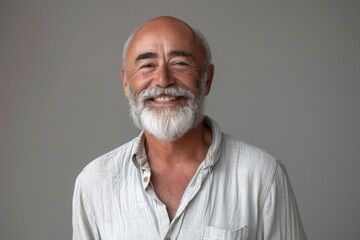 Fototapeta premium Elderly man smiling at camera. A close-up portrait of an elderly, man with a warm smile, wearing fashionable clothes.