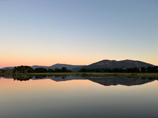 Reflection of a mountain and sunset skies in the water of river Minho near Tabagón, O Rosal, Galicia, Spain, January 2023