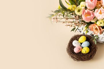 Colorful easter quail eggs in nest and beautiful bouquet of rose and tulips flowers on beige pastel...