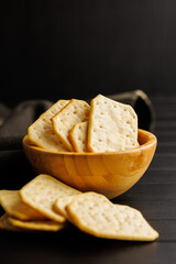 Salted Crackers in bowl Against a Dark Background