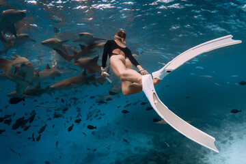 Woman snorkeling in tropical sea with nurse sharks in Bahamas