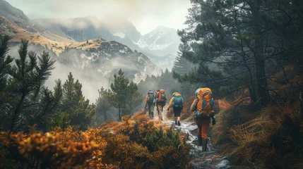 Zelfklevend Fotobehang Trekkers on a misty mountain path surrounded by autumn foliage. Moody landscape photography with an adventure theme for outdoor and travel design © Oksa Art