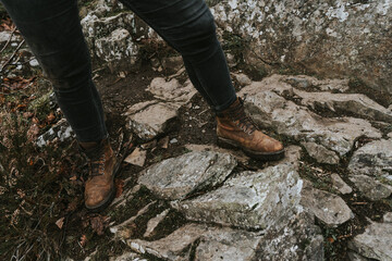 Closeup person climbing a rock with fashionable outfit