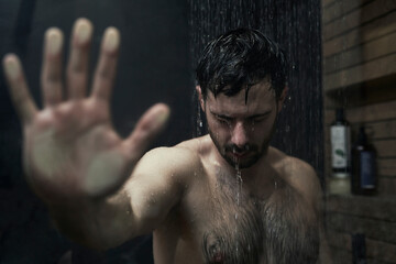 Man holding hand on shower glass
