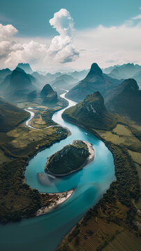 Breathtaking aerial view of a winding river amidst green mountains under a cloudy sky.