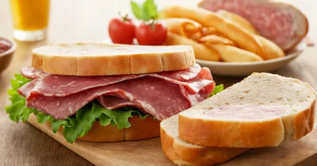 Foto op Plexiglas Mouthwatering assortment of deli meats, including ham, roast beef, and salami, stacked between slices of bread in this delectable sandwich clipart. © Issah