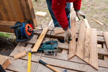 Worker sawing boards for construction - 762243943