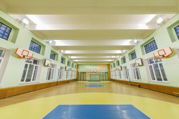 Wide-angle view of interior elementary school gym, large and bright