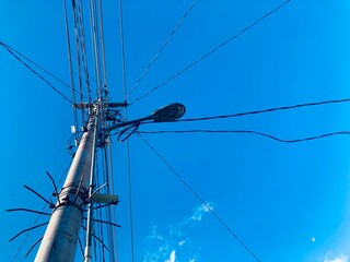 Electricity pole with wire against blue sky