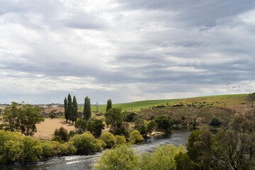 flowing river past farmland in summer, in the Tasmania wilderness. Lake with a Sandy beach and trees in Australia