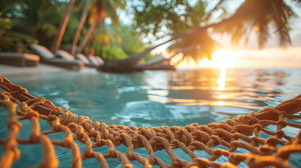 Fototapeta na wymiar Hammock near the swimming pool with palm trees at sunset.