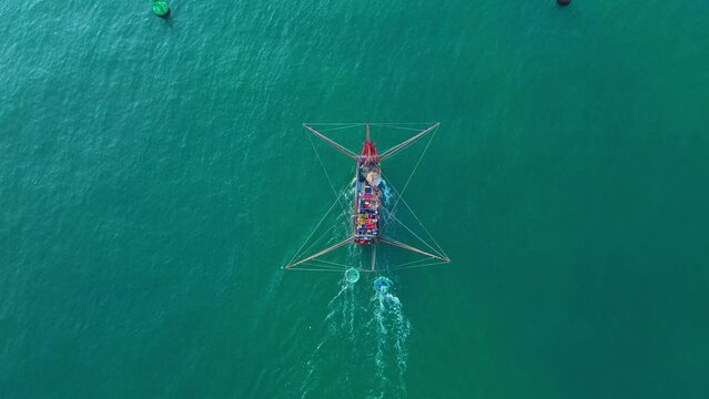 The fishing boat of Vietnamese fishermen is running on the sea in the morning during the trip to sea, aerial view. Travel and maritime background.
