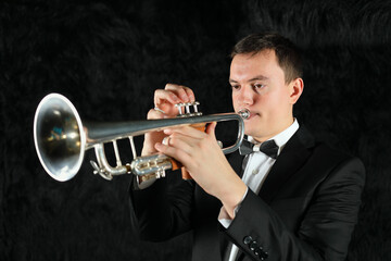 Portrait of trumpet player on black fur ground