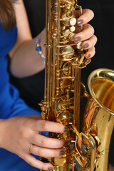 Obraz premium Close-up of saxophone in female hands