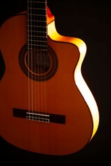 Fototapeta premium Classical Spanish flamenco guitar close up, dramatically lit isolated on black background with copy space.