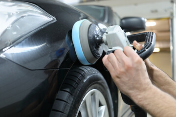 Polishing the cars black body with polishing machine