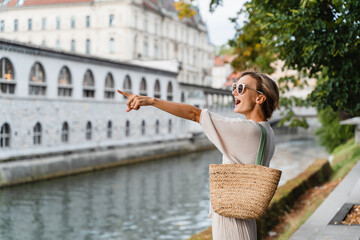 Smiling woman wearing stylish outfit walking on street of Ljubljana old town, Slovenia.Travel Europe - 762269548
