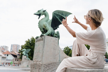 Young woman taking photo in front famous Dragon bridge in Ljubljana. Travel Explore Slovenia, Europe - 762270171